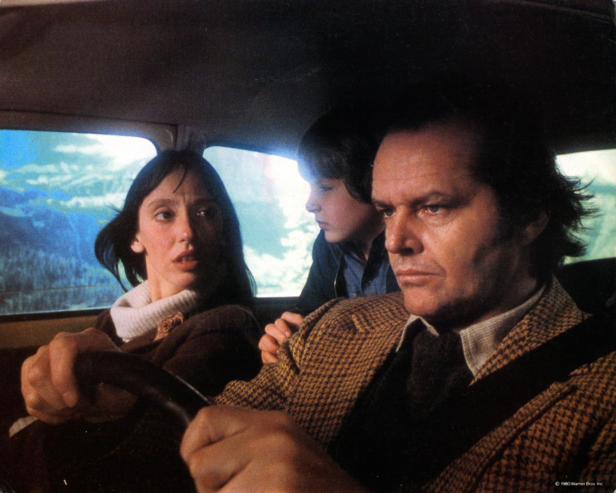 Jack, Wendy, and Danny ride toward the Overlook with the mountains visible outside the car.