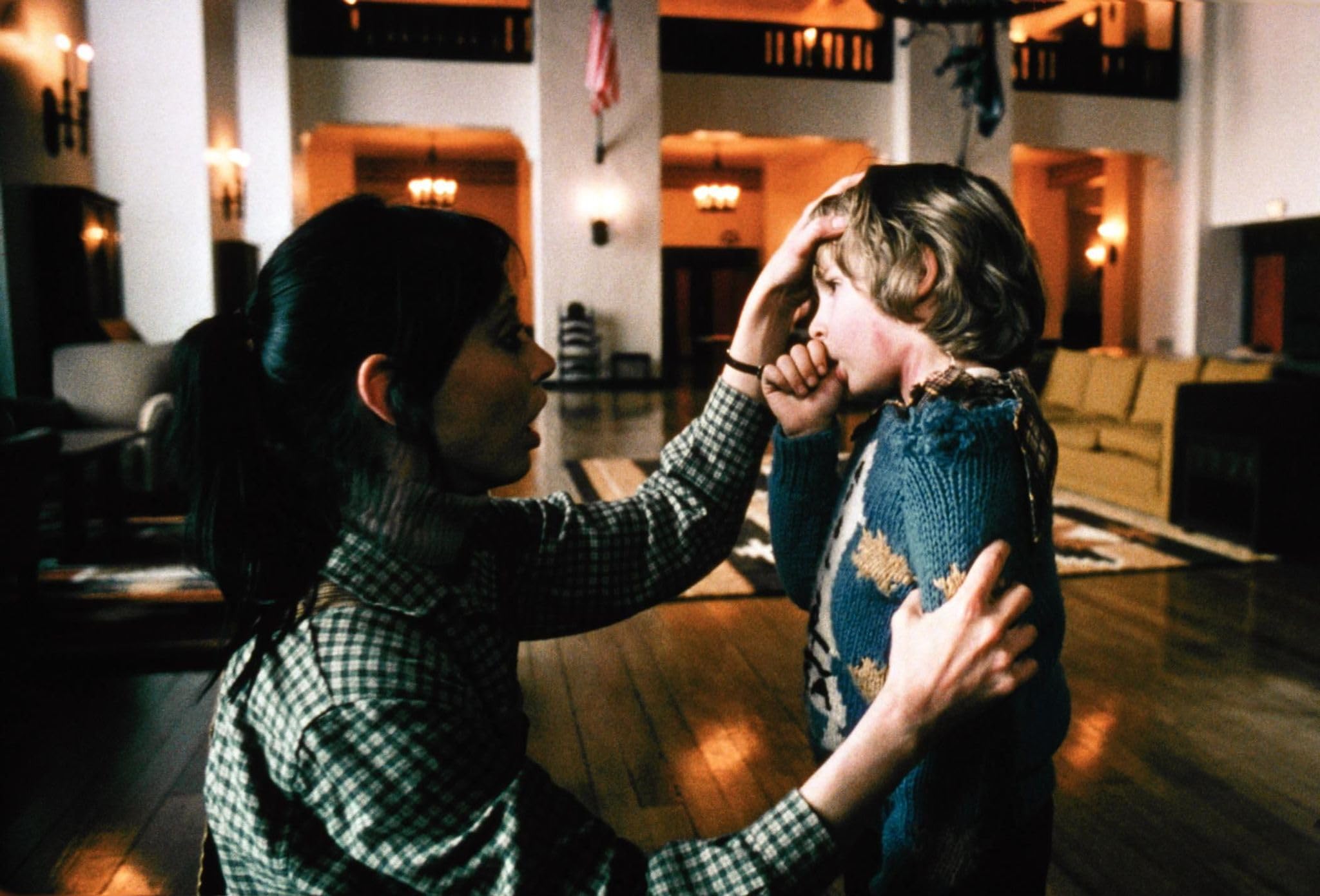 Wendy calms Danny in the spacious hotel lobby before the dread settles.